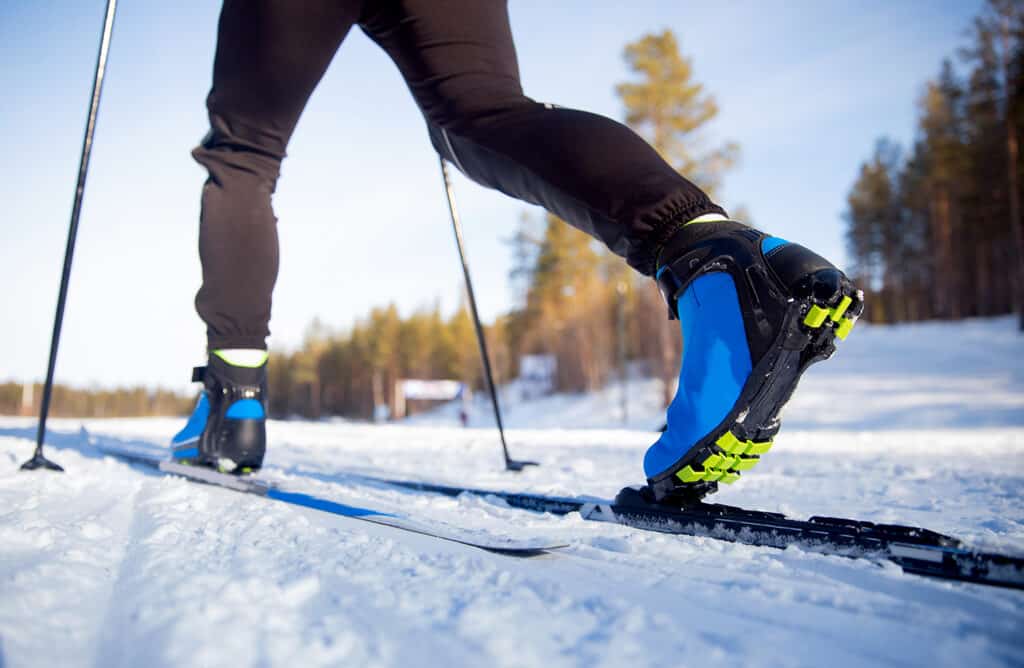 Les chaussures et bâtons de ski de fond glissent sur la neige fraîche